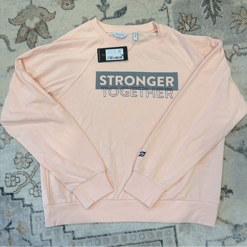 Pink Peloton Stronger Together sweatshirt.